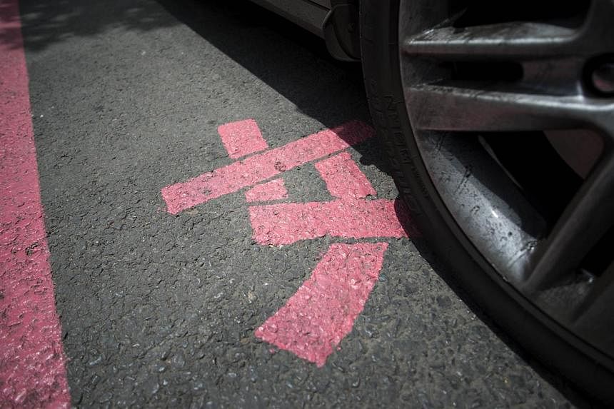 This photo taken on July 7, 2014, shows the Chinese character 'nu' meaning woman, on a pink marked out parking space in front of the Dashijiedaduhui, or World Metropolis centre, in the seaport city of Dalian, north-east China's Liaoning province. -- 