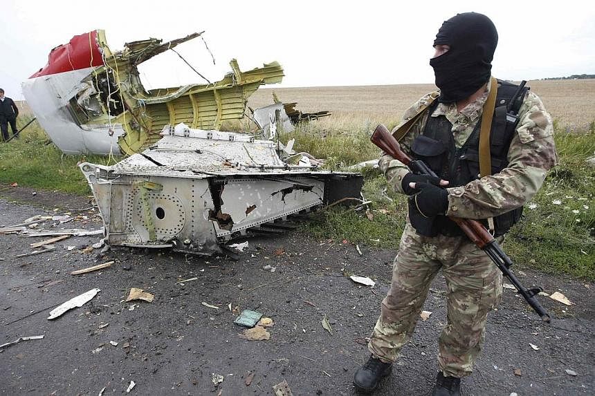 A pro-Russian separatist stands at the crash site of Malaysia Airlines flight MH17, near the settlement of Grabovo in the Donetsk region on July 18, 2014.&nbsp;Ukraine and pro-Russian rebels have agreed to set up a security zone around the crash site