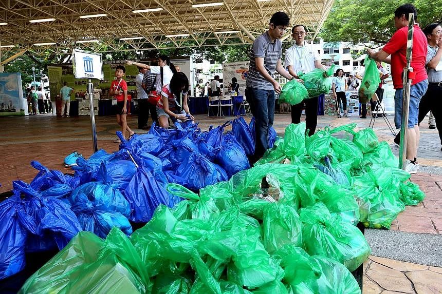 About 250 volunteers used a new litter-picking tool kit, which includes litter pickers, trash bags, wet wipes and a guide, as they cleaned up the neighbourhoods in Bedok on Saturday. -- ST PHOTO: CHEW SENG KIM