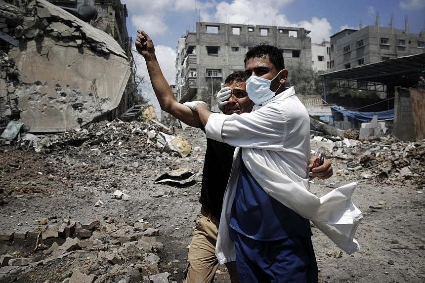 A medic helps a Palestinian in the Shejaia neighbourhood, which was heavily shelled by Israel during fighting, in Gaza City on Sunday, July 20, 2014.&nbsp;US Secretary of State John Kerry on Sunday blamed Hamas for the continuation of the conflict in