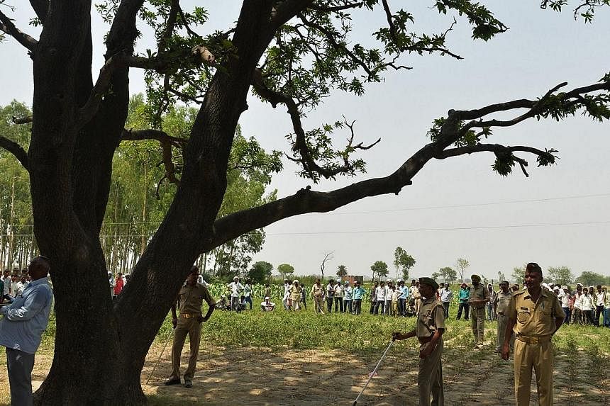 Indian police keep watch under the tree where the bodies of two gang-rape victims were found hanging in the village of Katra Shahadatgunj in Badaun in the Indian state of Uttar Pradesh,&nbsp;on May 31, 2014.&nbsp;India's monsoon rains on Sunday, July