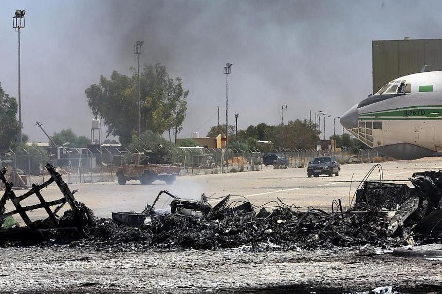 &nbsp;A picture taken on July 16, 2014, shows the remains of a burnt airplane at the Tripoli international airport in the Libyan capital.&nbsp;&nbsp;The Philippines on Sunday, July 20, 2014, ordered its estimated 13,000 nationals in Libya to flee tha