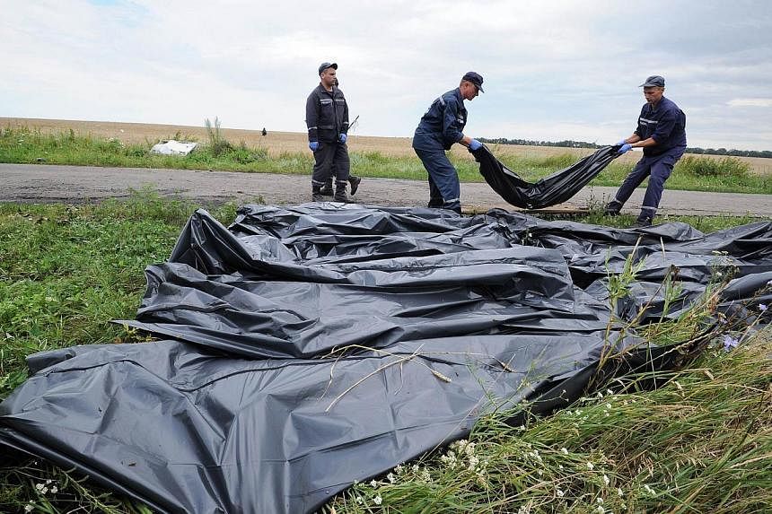 Ukrainian rescue workers collect bodies of victims at the site of the crash of a Malaysia Airlines plane carrying 298 people from Amsterdam to Kuala Lumpur in Grabove, in rebel-held east Ukraine.&nbsp;Scores of bodies that had been gathered at the ma