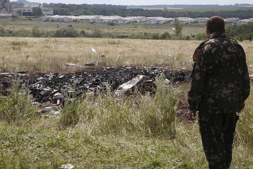 A pro-Russian separatist stands at the crash site of Malaysia Airlines Flight MH17, near the settlement of Grabovo in the Donetsk region on July 19, 2014.&nbsp;A top Ukrainian rebel leader said on Sunday, July 20, 2014 that the pro-Russian fighters w