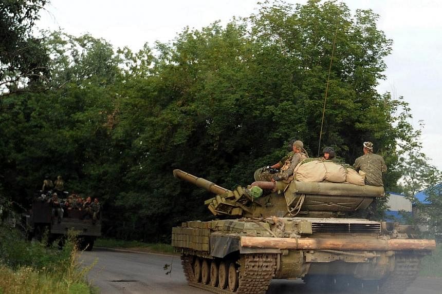 Pro-Russian separatists ride a tank near Donetsk, eastern Ukraine, on July 19, 2014.&nbsp;A spokesman for Ukraine's Security Council said on Sunday, July 20, 2014, that Russia was continuing to send "heavy weaponry" and other arms to separatists figh