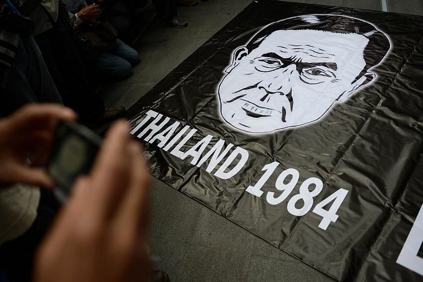 This file photo taken on June 1, 2014 show A banner carrying a drawing depicting Thai army chief General Prayut Chan-O-Cha and a reference to George Orwell's famous dystopian novel "1984" is displayed during a gathering at a shopping mall which was b