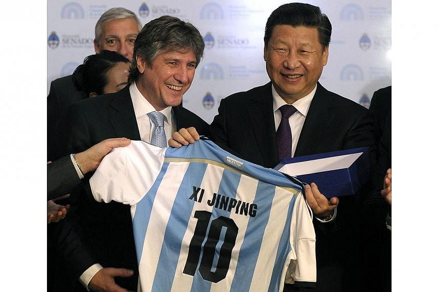 China's President Xi Jinping (right) receives an Argentine soccer jersey with his name on it from Argentina's Vice President Amado Boudou as Xi visits the Congress in Buenos Aires on July 19, 2014. -- PHOTO: REUTERS