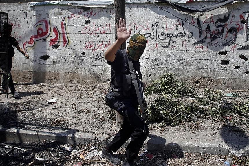 An armed Hamas militant walks in a street in Gaza's eastern Shejaiya district on July 20, 2014. -- PHOTO: AFP