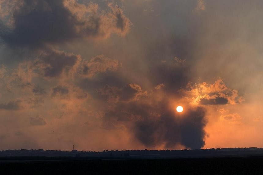 A picture taken on July 20, 2014, from Israel at the southern border with the Gaza strip shows smoke billowing from behind a hill following an Israeli air strike on Gaza City. -- PHOTO: AFP