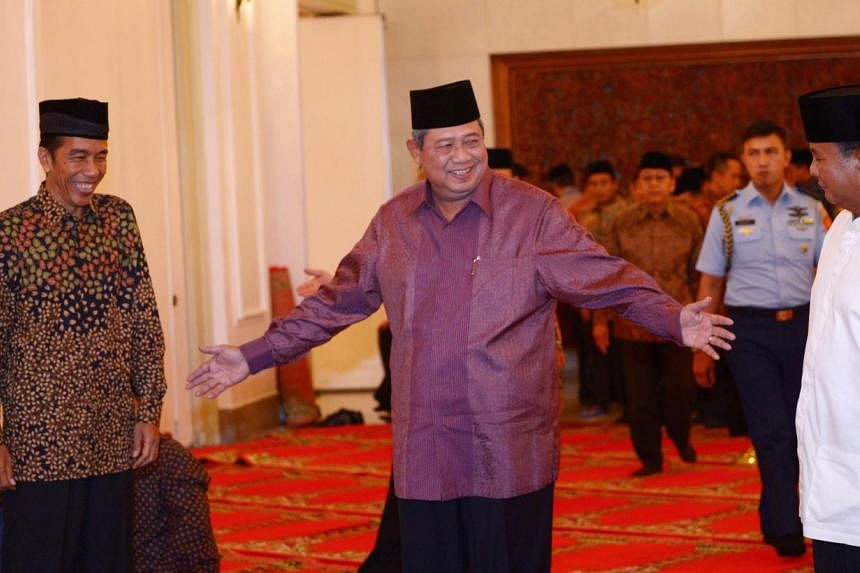 Indonesian president Susilo Bambang Yudhoyono (C) gestures to presidential candidates Joko Widodo (L) and Prabowo Subianto (R) prior to a breaking of fast at the presidential palace in Jakarta on July 20, 2014. &nbsp;Mr Joko is expected to be declare