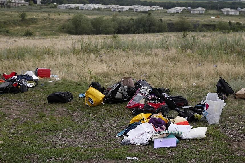 Luggage and belongings are seen near the site of Malaysia Airlines Boeing 777 plane crash, near the settlement of Grabovo in the Donetsk region on July 18, 2014. -- PHOTO: REUTERS