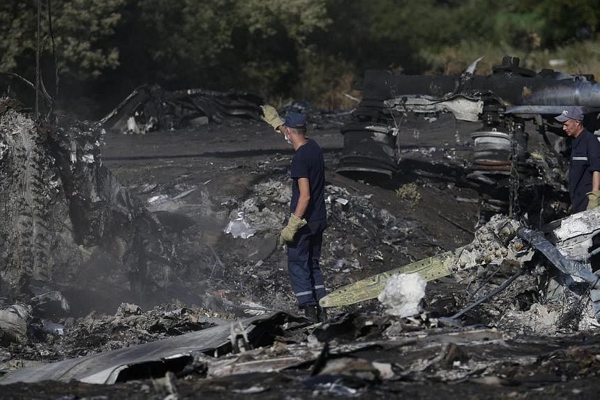 Members of the Ukrainian Emergencies Ministry work at the crash site of Malaysia Airlines Flight MH17 near the village of Hrabove, Donetsk region, on July 20, 2014. -- PHOTO: REUTERS