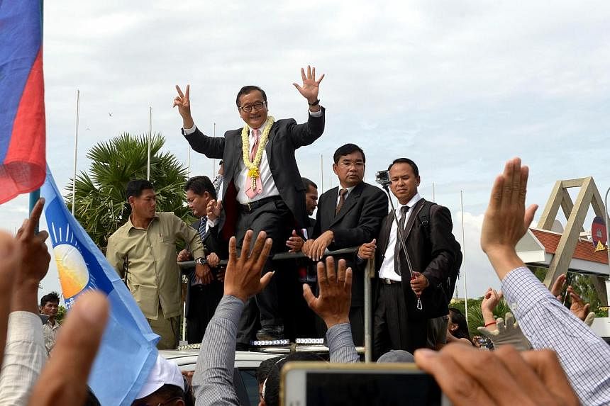 Cambodian opposition leader Sam Rainsy (centre) greets his supporters along a street in Phnom Penh on July 19, 2014.&nbsp;Cambodia's prime minister and the leader of the opposition are set for their first face-to-face talks for nearly a year on Tuesd