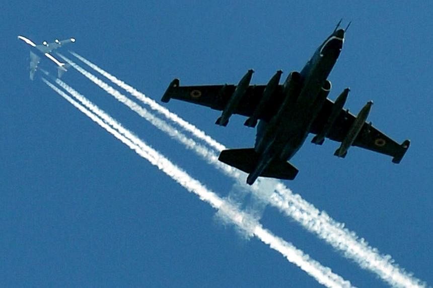 This file photo taken on September 27, 2012 not far from the Ukrainian city of Ghytomyr, some 170 km from Kiev, shows a Ukrainian Su-25 flying below a passenger aircraft during military exercises called Perspekyiva-2012 (Perspective-2012).&nbsp;Russi