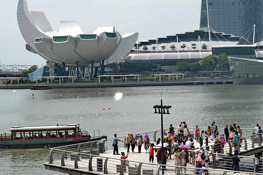 Tourists view the Marina Bay Sands resort hotel and casino from a pier at Merlion park in Singapore on June 24, 2014.&nbsp;The tourism receipt tally in Singapore rose to $6 billion in the first quarter of 2014, a five per cent increase on the same pe