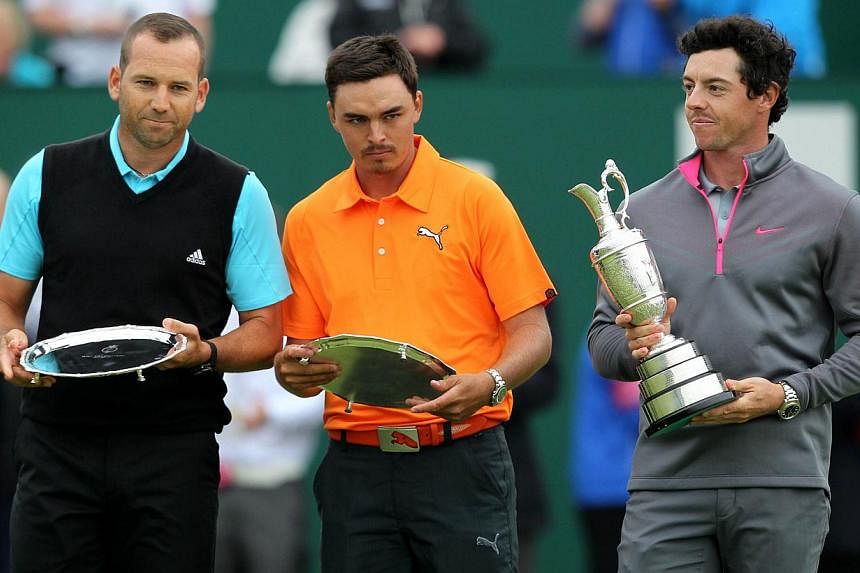 Spain's Sergio Garcia (left) and US golfer Rickie Fowler stand with their second place trophies beside Northern Ireland's Rory McIlroy (right) after finishing two strokes behind winner at Royal Liverpool Golf Course in Hoylake, north west England on 