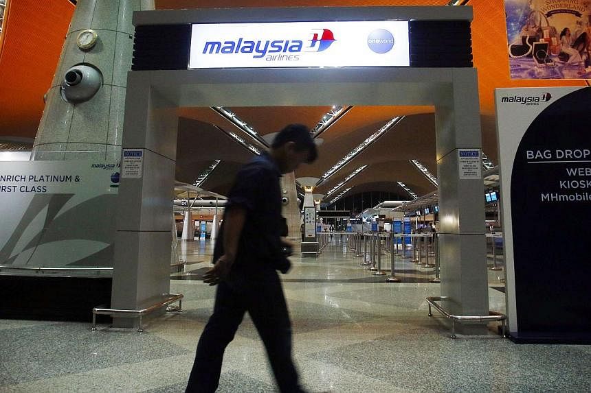 A man walks past the Malaysia Airlines check-in area at Kuala Lumpur International Airport in Sepang on July 18, 2014. -- PHOTO: REUTERS