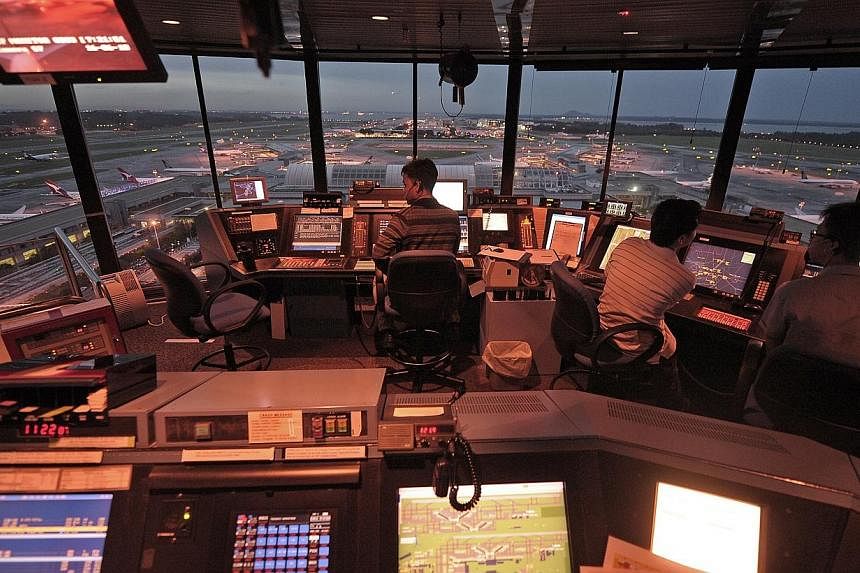 Air traffic controllers work inside the iconic Changi Airport control tower.&nbsp;Scholarships in the aviation industry are highly sought after by A-Level and International Baccalaureate (IB) Diploma graduates, a new survey has found. -- PHOTO: ST FI