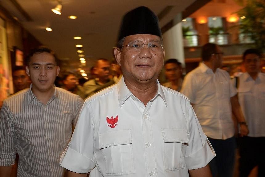 Indonesian candidate Prabowo Subianto (centre) walks with his team after a meeting in Jakarta on July 20, 2014.&nbsp;-- PHOTO: AFP