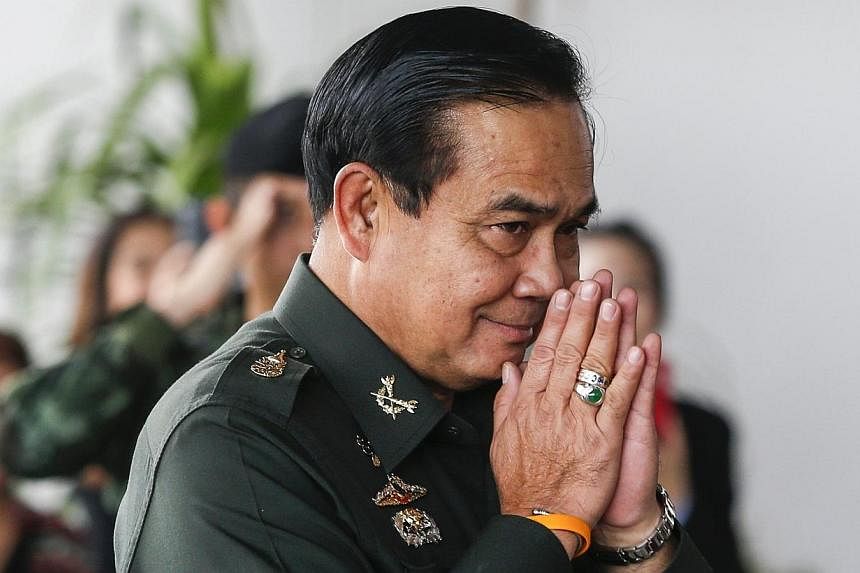 Thai Army chief General Prayuth Chan-ocha makes a gesture of greeting as he arrives ahead of a meeting to discuss the 2015 national budget at the Army Club in Bangkok on June 13, 2014.&nbsp;Thailand's junta won approval from the king Tuesday, July 22