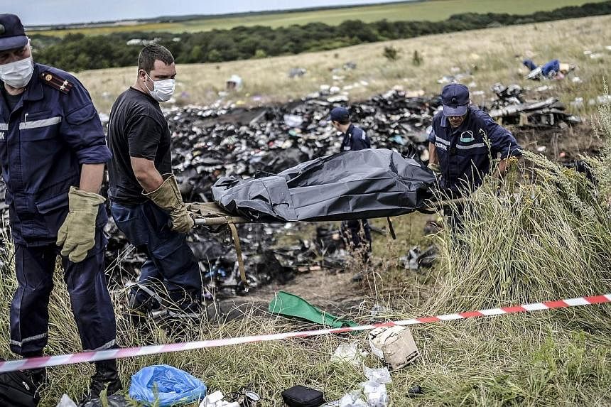 Ukrainian State Emergency Service employees collect bodies of victims at the site of the crash of a Malaysia Airlines plane in Grabove, in rebel-held east Ukraine on July 20, 2014.&nbsp;Malaysia's leaders worked quietly behind the scenes to secure th