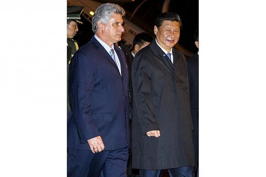 China President Xi Jinping (right) is welcomed by Cuban Vice-President Miguel Diaz Canel (left) at Havana International Airport Jose Marti on July 21, 2014.&nbsp;Chinese President Mr Xi Jinping visited Cuba on Tuesday, July 22, 2014, to expand invest