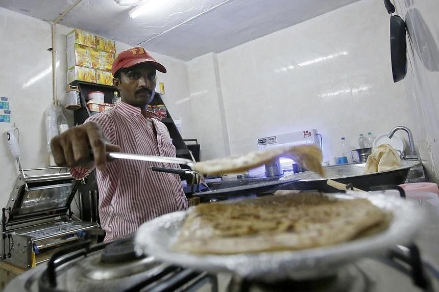An inmate prepares food inside the kitchen of a restaurant run by the Tihar Jail authorities on Jail Road in west Delhi on July 21, 2014. -- PHOTO: REUTERS