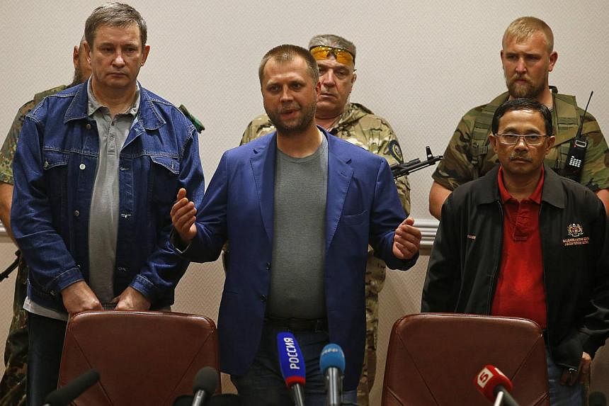 Senior Ukrainian separatist leader Aleksander Borodai (centre) speaks during a handover of Malaysia Airlines flight MH17's black boxes to Colonel Mohamed Sakri (right) of the Malaysian National Security Council, in Donetsk on July 22, 2014. -- PHOTO: