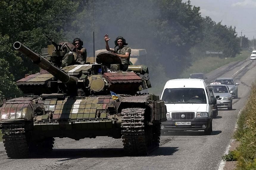 Ukrainian troops are pictured in front of cars in the eastern Ukrainian town of Konstantinovka July 21, 2014. Fighting broke out near the railway station at the heart of the rebel stronghold of Donetsk on Monday in what separatists said was an attemp
