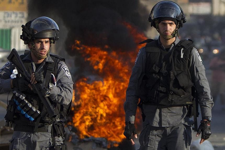 Israeli riot police keep watch during clashes that followed a protest against Israel's military offensive on the Gaza Strip, in the northern city of Nazareth, on July 21, 2014. -- PHOTO: AFP
