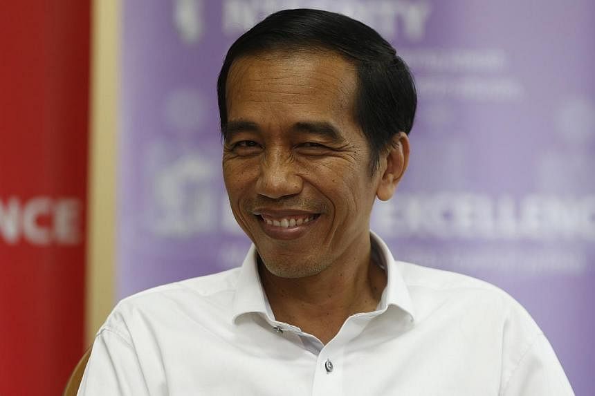 Indonesia's presidential candidate Joko Widodo smiles during a talk with his supporters at the Bisnis Indonesia newspaper office in Jakarta, on July 21, 2014. -- PHOTO: REUTERS