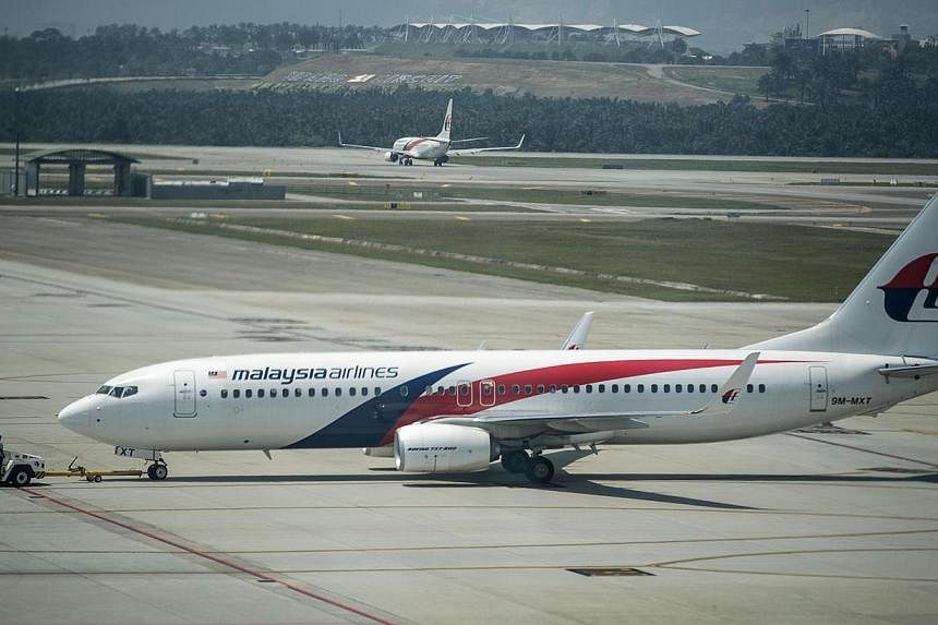 A Malaysia Airlines plane is seen on the tarmac at Kuala Lumpur International Airport in Sepang on July 21, 2014. -- PHOTO: AFP