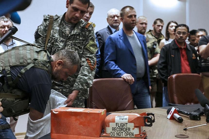 A pro-Russia separatist shows members of the media a black box belonging to Malaysia Airlines flight MH17, before handing it over to Malaysian representatives during a press conference in Donetsk on July 22, 2014.&nbsp;Malaysia said on Tuesday it wil