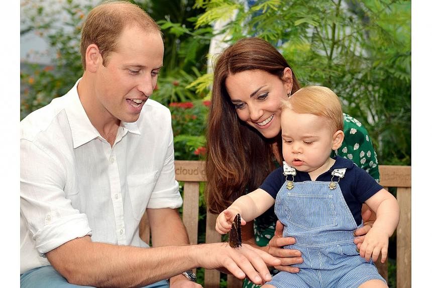 A photograph taken in London on Wednesday July 2, 2014, to mark Britain's Prince George's first birthday, shows Prince William (left) and Catherine, Duchess of Cambridge with Prince George during a visit to the Sensational Butterflies exhibition at t