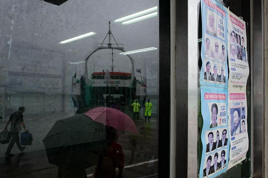 In a photo taken on July 6, 2014 a wanted poster for fugitive Chonghaejin owner Yoo Byung-Eun is displayed in a window in Jindo harbour, where families of the victims of the Sewol ferry still unaccounted for continue to wait. -- PHOTO: AFP &nbsp;
