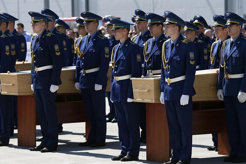 Honour guards take part in a ceremony with coffins of some of the victims of Malaysia Airlines MH17, which was downed over rebel-held territory in eastern Ukraine, before they are loaded onto a transport plane heading to the Netherlands at Kharkiv ai