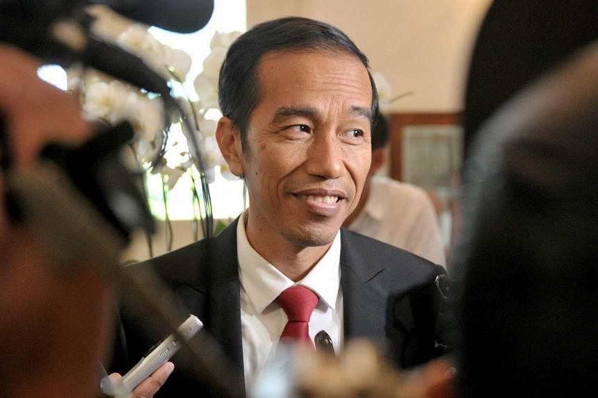 Indonesian president elect Joko Widodo (centre) answers questions from the media in Jakarta on July 23, 2014 as he returns to work after the General Elections Commission declared him the winner of the presidential elections.&nbsp;-- PHOTO: AFP