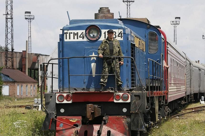 A guard stands on a train carrying the remains of victims of Malaysia Airlines MH17 downed over rebel-held territory in eastern Ukraine after it arrived in the city of Kharkiv, eastern Ukraine on July 22, 2014. -- PHOTO: REUTERS