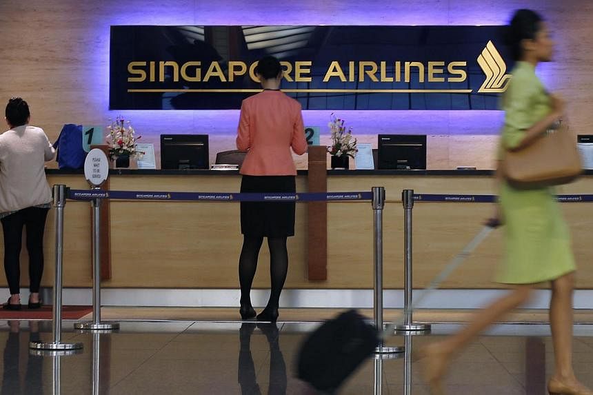 People walk past a Singapore Airlines ticketing counter at Changi Airport in Singapore. SIA, which has been criticised for flying over Ukraine before Thursday's Malaysia Airlines crash, has confirmed that it had been avoiding parts of the country's a