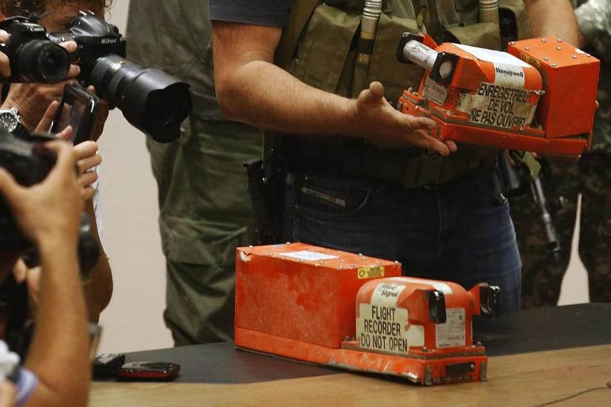 Members of the media take pictures as a pro-Russian separatist places black boxes belonging to Malaysia Airlines flight MH17 on a desk, before their handover to Malaysian representatives, in Donetsk on July 22, 2014. -- PHOTO: REUTERS