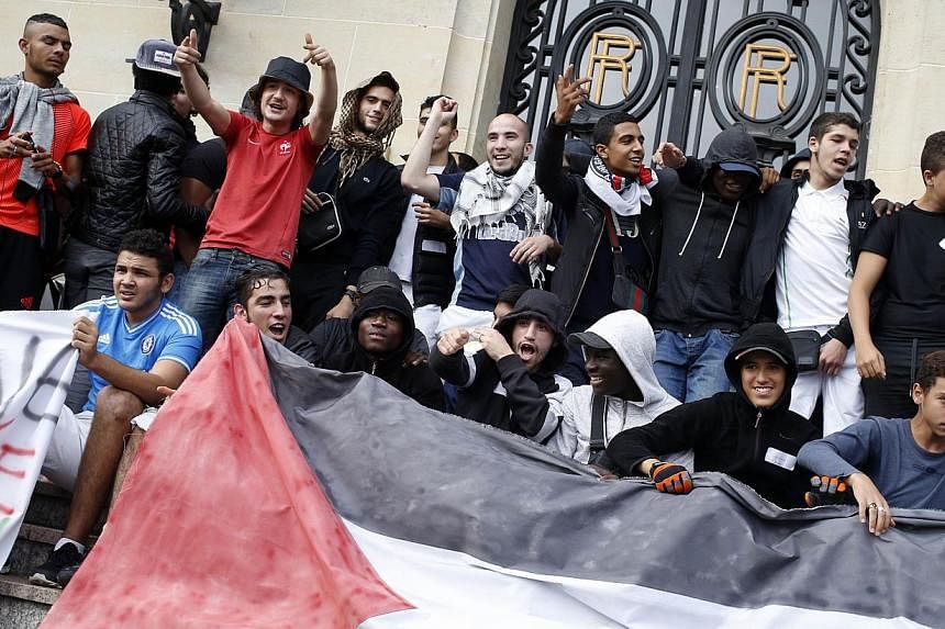 Protestors hold a Palestinian flag as they take part in a demonstration on July 22, 2014 to denounce Israel's military campaign in Gaza and to show their support to the Palestinian people in Aulnay-sous-Bois, north suburb of Paris. -- PHOTO: AFP&nbsp