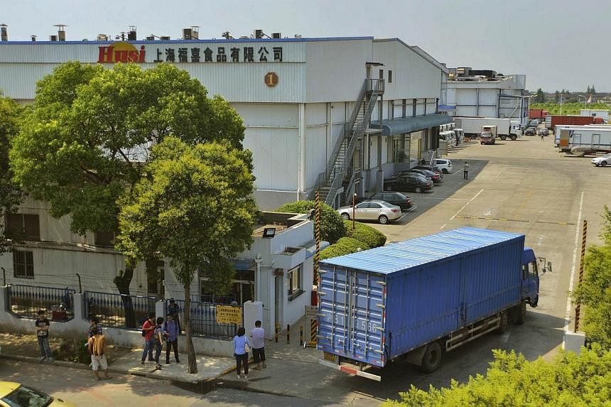 A truck drives past a building of the seized Shanghai Husi Food factory on July 21, 2014. The latest food scandal in China is spreading fast, dragging in US coffee chain Starbucks, Burger King Worldwide and others, as well as McDonald's products as f