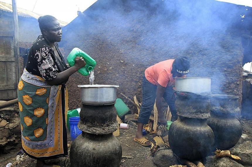 Mama Jane Adhiambo prepares distilled traditional brewed alcoholic liquor, locally known as "chang'aa", at an illegal micro-brewery in Kibera slum in the suburbs of Kenya's capital Nairobi May 11, 2014 -- PHOTO: REUTERS