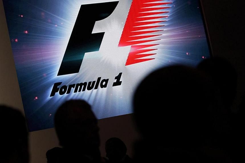 Reporters are silhouetted by a screen showing a F1 logo during a news conference to announce a Formula One race in Mexico City on July 23, 2014. -- PHOTO: REUTERS