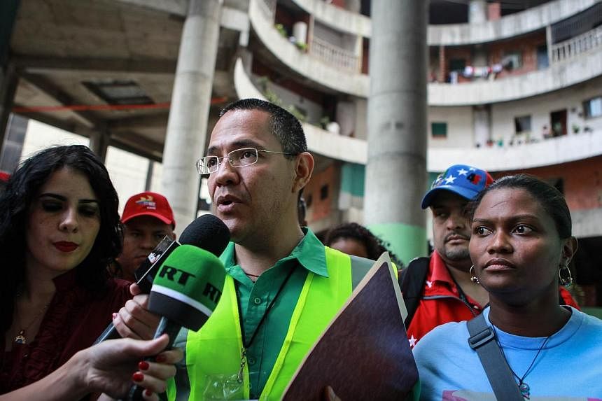The Minister of State for the Urban Transformation of Greater Caracas, Mr Ernesto Villegas, speaks to the press during the eviction of the Tower of David, an abandoned skyscraper in Caracas originally intended to be an office building that became a '