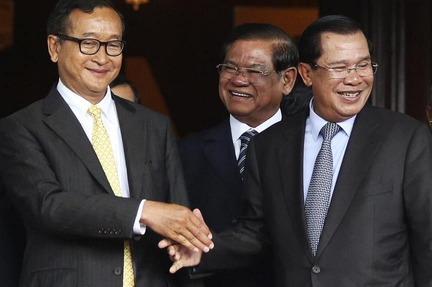 Cambodia's Prime Minister Hun Sen (right) shakes hands with Sam Rainsy (left), president of the Cambodia National Rescue Party (CNRP), after a meeting at the Senate in central Phnom Penh July 22, 2014. Both men met in an attempt to solve a year-long 