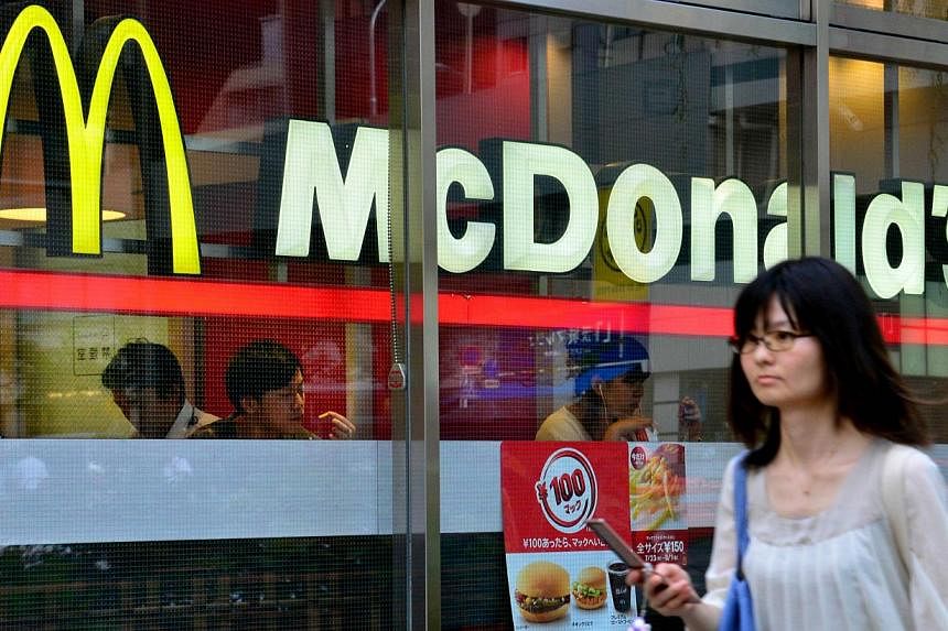 A pedestrian passes before a McDonald's restaurant in Tokyo on July 23, 2014. -- PHOTO: AFP