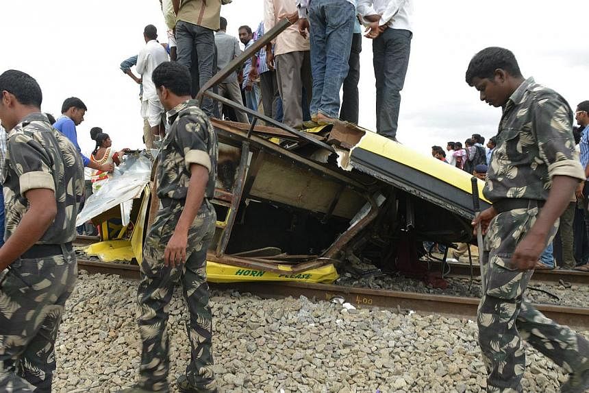 Indian police walk at the scene of the collision between a school bus and a train at Thoopran Mandal of Medak District, about&nbsp;58km  from Hyderabad, on July 24, 2014. -- PHOTO: AFP