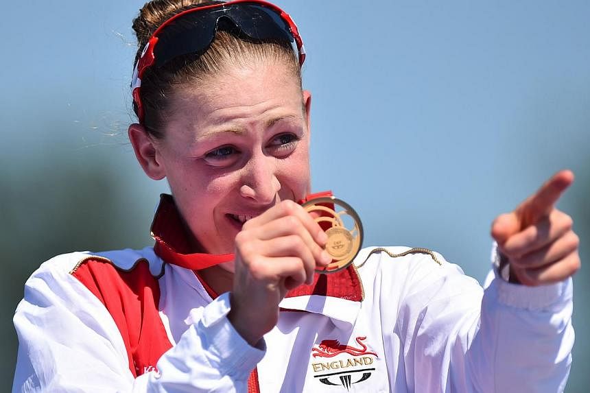 England's Jodie Stimpson celebrates after winning the gold medal in the Women's Triathlon during the 2014 Commonwealth Games at Strathclyde Country Park near Glasgow, Scotland on July 24, 2014. -- PHOTO: AFP&nbsp;