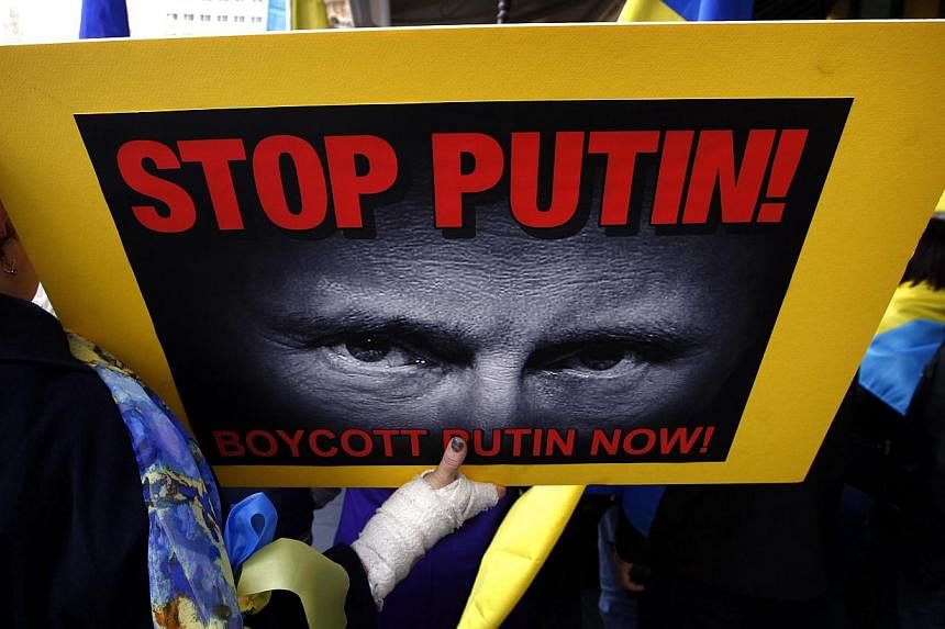 Members of the Australian Ukrainian community hold placards as they hold a rally in Sydney on July 19, 2014, demanding that Russian President Vladimir Putin not be allowed to attend the G20 Leaders Summit in November. -- PHOTO: REUTERS